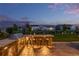 An outdoor kitchen with a built in grill and bar seating overlooks the fenced backyard at 3256 Offbeaten Pl, Castle Rock, CO 80108