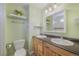Bathroom featuring double sinks, a toilet, open shelving, and neutral tile at 113 Oakdale Dr, Palmer Lake, CO 80133