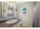 Bright bathroom with a window, a large mirror, and a sink with a dark countertop at 113 Oakdale Dr, Palmer Lake, CO 80133