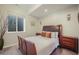 Well-lit bedroom featuring a plush bed, dark wood accents, and a view from the window at 113 Oakdale Dr, Palmer Lake, CO 80133