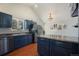 Bright kitchen features a peninsula with seating, blue cabinets, stainless steel appliances, and hardwood floors at 113 Oakdale Dr, Palmer Lake, CO 80133