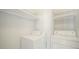 A laundry room with a washing machine and dryer with white walls and shelves at 113 Oakdale Dr, Palmer Lake, CO 80133