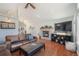 Inviting living room with a stone fireplace, ceiling fan, and rich hardwood floors at 113 Oakdale Dr, Palmer Lake, CO 80133