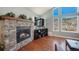 Living room features a stone fireplace, display shelves, and bright windows with mountain views at 113 Oakdale Dr, Palmer Lake, CO 80133
