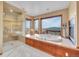 Bright bathroom with a soaking tub, large windows offering scenic views, and a walk-in shower at 260 Dekker Dr, Golden, CO 80401