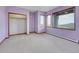 Bedroom featuring three windows with scenic views, lilac walls, and grey carpet at 260 Dekker Dr, Golden, CO 80401