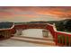 Outdoor deck with a red railing and decorative flower pots overlooks a scenic landscape and sunset at 260 Dekker Dr, Golden, CO 80401