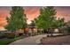 Charming brick home featuring a well-manicured lawn, mature trees, and a curved driveway at 260 Dekker Dr, Golden, CO 80401