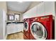 Well-lit laundry room featuring red washer and dryer units and ample counter space at 260 Dekker Dr, Golden, CO 80401