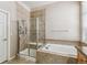 Elegant bathroom featuring a soaking tub, glass-enclosed shower, and tiled accents at 6085 Nile Cir, Golden, CO 80403