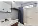 Bathroom featuring a shower/tub combo, modern vanity, and glass block window for natural light at 5570 Nepal St, Denver, CO 80249