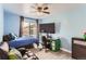 Bright bedroom features a ceiling fan, a large window and space for a study desk and comfy couch at 5570 Nepal St, Denver, CO 80249