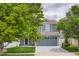 Two-story home boasts a well-kept lawn, large front window, and an attached two-car garage at 5570 Nepal St, Denver, CO 80249