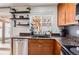 This kitchen boasts dark countertops, stainless steel appliances, and plentiful natural light at 5570 Nepal St, Denver, CO 80249