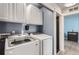 Well-lit laundry room featuring a modern washer and dryer set and ample cabinet space for storage at 5570 Nepal St, Denver, CO 80249