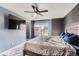 The main bedroom with ceiling fan, TV, and a sun-filled window offering neighborhood views at 5570 Nepal St, Denver, CO 80249