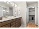 Bathroom featuring a double sink vanity, modern fixtures, and a walk-in closet for ample storage at 244 Chipeta Way, Lochbuie, CO 80603