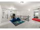 Bright bonus room with comfortable blue seating area and upstairs hallway at 244 Chipeta Way, Lochbuie, CO 80603