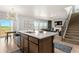 Island sink in open kitchen overlooking a living area with a fireplace and large backyard views at 244 Chipeta Way, Lochbuie, CO 80603