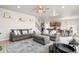 Open concept living room features hardwood floors and comfortable seating with a view into the kitchen at 244 Chipeta Way, Lochbuie, CO 80603