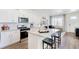 Well-lit kitchen featuring modern appliances, white cabinets, and an inviting breakfast bar at 956 Andrews Crest Dr, Berthoud, CO 80513