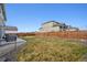 A spacious fenced-in backyard with a stone area around the grass, providing privacy and room to play at 11783 Niagara St, Thornton, CO 80233