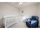 Cozy Bedroom with a white crib, comfortable armchair, and soft neutral tones at 11783 Niagara St, Thornton, CO 80233