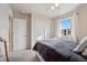 Bright bedroom with a sliding closet, neutral decor, and natural light streaming through the window at 11783 Niagara St, Thornton, CO 80233
