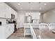 Modern kitchen features white cabinets, stainless steel appliances, and an island with seating at 11783 Niagara St, Thornton, CO 80233