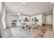 Bright, open kitchen featuring an island, white cabinetry, stainless steel appliances, and an adjacent dining area at 11783 Niagara St, Thornton, CO 80233