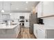 Modern kitchen featuring white cabinetry, quartz countertops, stainless steel appliances, and wood-style flooring at 11783 Niagara St, Thornton, CO 80233