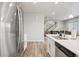 Bright kitchen with stainless appliances, quartz countertop island, and open access to the living area at 11783 Niagara St, Thornton, CO 80233