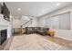 Cozy living room featuring a plush sectional sofa, a modern fireplace, and a staircase at 11783 Niagara St, Thornton, CO 80233