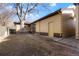 Backyard area with large tree, pea gravel, and building exterior with windows and doors at 2695 S Josephine St, Denver, CO 80210