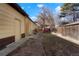 Backyard exterior with pea gravel, wooden fence, and building exterior of home with two doors at 2695 S Josephine St, Denver, CO 80210
