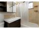 Tiled bathroom featuring a vanity, a shower-tub combo, and a window at 2695 S Josephine St, Denver, CO 80210