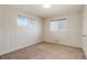 This carpeted bedroom has two windows, white paneled walls, and a neutral palette at 2695 S Josephine St, Denver, CO 80210