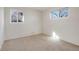 This carpeted bedroom has two windows, white walls, and a neutral color scheme at 2695 S Josephine St, Denver, CO 80210