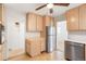 Bright kitchen features wood cabinets, stainless steel refrigerator, and wood-look flooring at 2695 S Josephine St, Denver, CO 80210