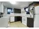 The basement kitchen features wood-look flooring, black cabinets, and white appliances at 2695 S Josephine St, Denver, CO 80210