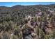 A high-angle aerial perspective displays a house enveloped by a lush forest at 268 Cedar Rd, Golden, CO 80401