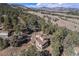 Aerial view shows a house nestled in a dense forest, providing privacy and seclusion at 268 Cedar Rd, Golden, CO 80401