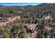 A distant aerial view reveals a house nestled among tall trees at 268 Cedar Rd, Golden, CO 80401