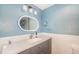 Modern bathroom featuring an oval mirror and a gray vanity with quartz countertops at 268 Cedar Rd, Golden, CO 80401