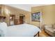 Bright bedroom featuring wood floors, a comfy chair and large window with tree views at 268 Cedar Rd, Golden, CO 80401