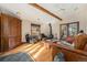 Living room featuring hardwood floors, wood beams, fireplace, and sliding doors to a deck area at 268 Cedar Rd, Golden, CO 80401