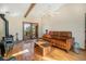 Bright living room with hardwood floors, wood beams, a fireplace, and comfortable seating under a ceiling fan at 268 Cedar Rd, Golden, CO 80401