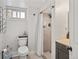 Bathroom featuring a toilet and tiled shower with curtain, with vanity and dark cabinets at 3241 Sheridan Blvd, Wheat Ridge, CO 80212