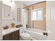 Well-lit bathroom featuring a shower-tub combo with tiled surround and modern fixtures at 3241 Sheridan Blvd, Wheat Ridge, CO 80212