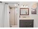 Bathroom featuring a tiled shower, vanity with dark wood cabinets, and decorative mirror at 3241 Sheridan Blvd, Wheat Ridge, CO 80212